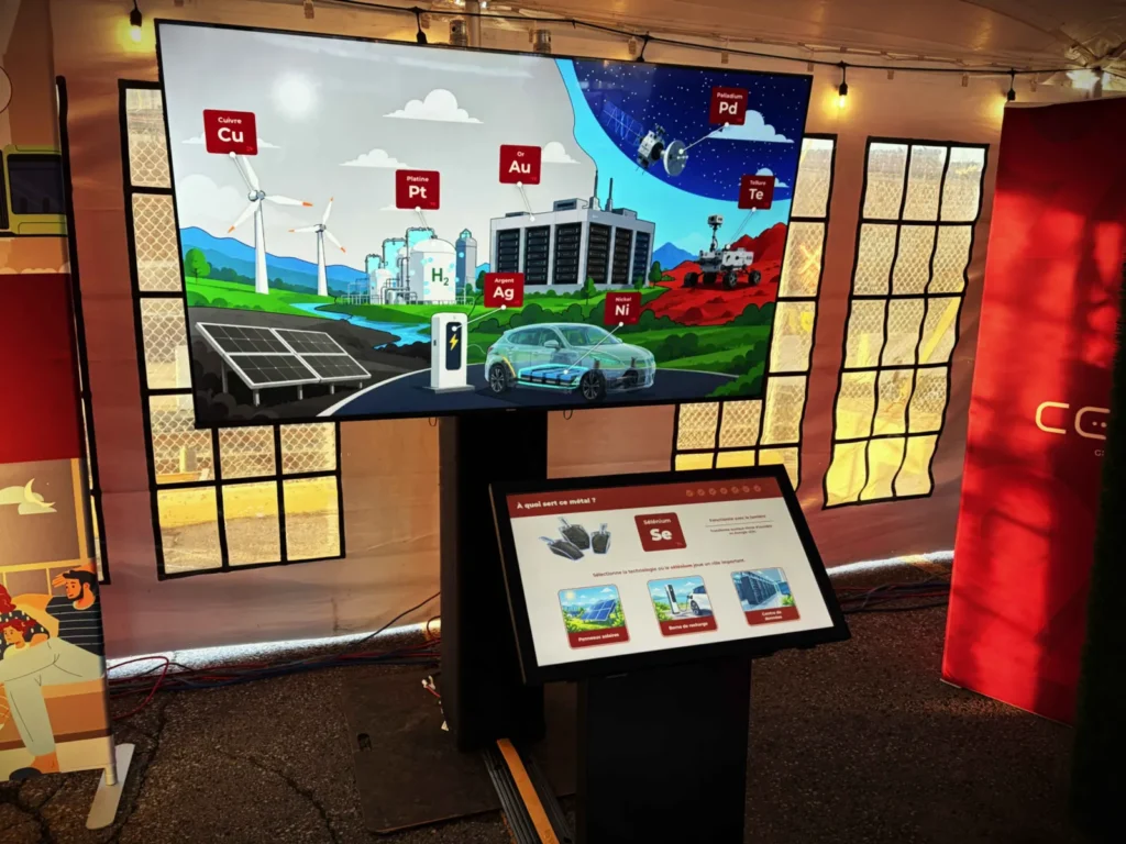 An interactive installation featuring a quiz on a touchscreen and a large display facing it.