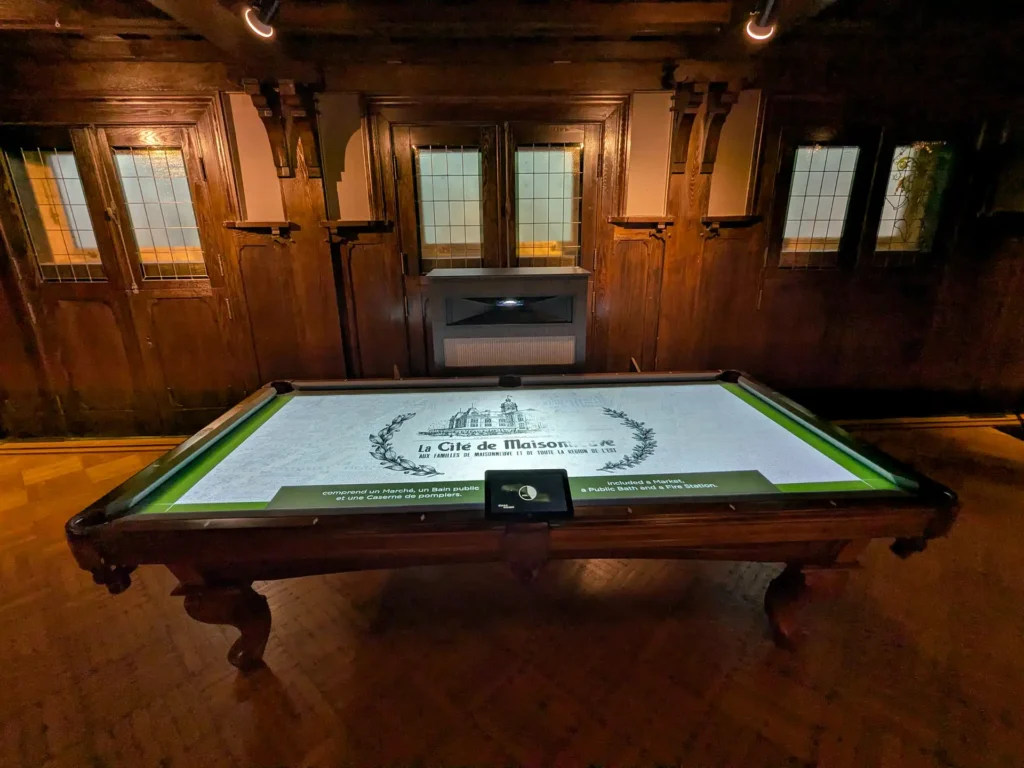 Vue d'ensemble de la projection sur la table de billard avec l'écran tactile dans la salle de billard du Chateau Dufresne, projet réalisé par Simbioz.